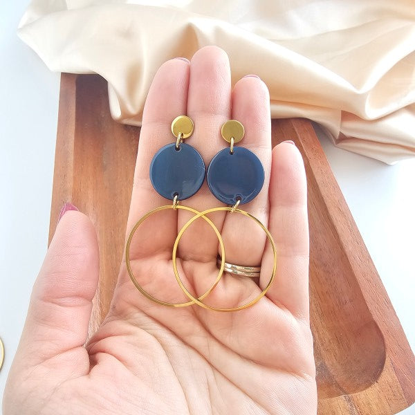 Woman holding Sadie Earrings – Navy, displaying hoop-inspired dangle design.