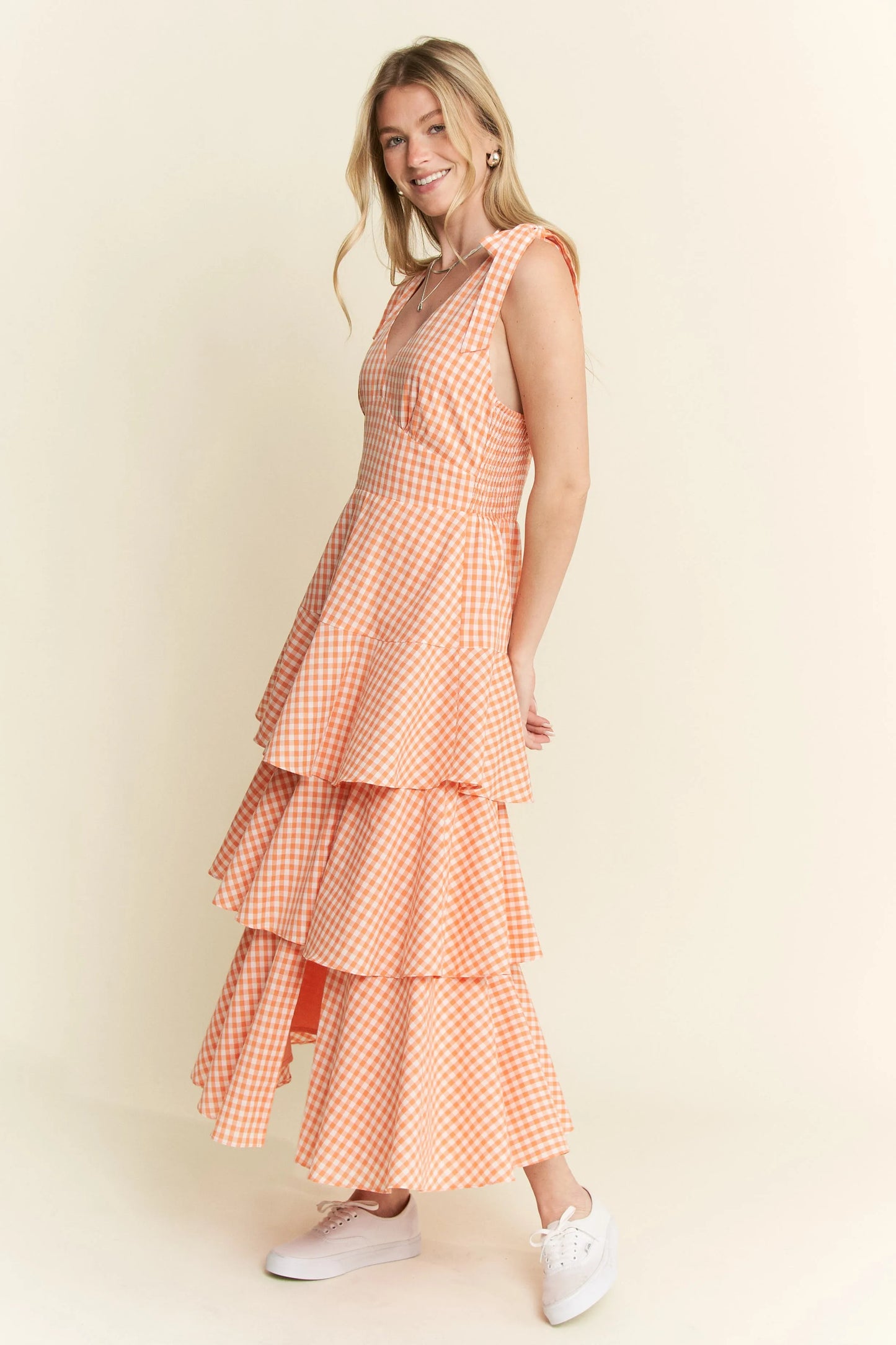 Side view full body of model wearing Alice Gingham Tiered Midi Dress by Jade by Jane, featuring halter neckline, ruffled tiers, and vibrant orange gingham print.