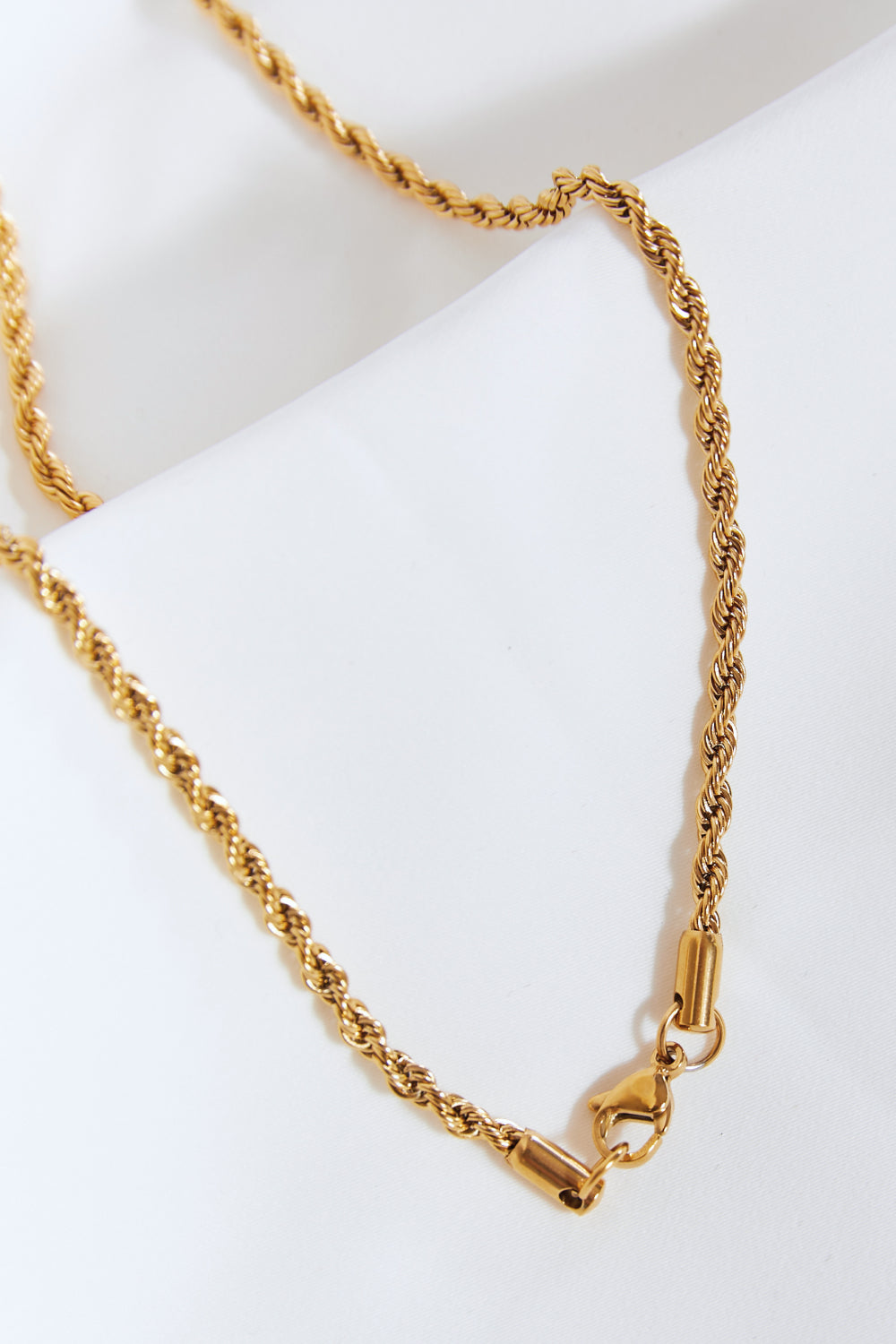 Lightning pendant necklace with a twisted chain, crafted from brass, stainless steel, and cubic zirconia for a sparkling touch.