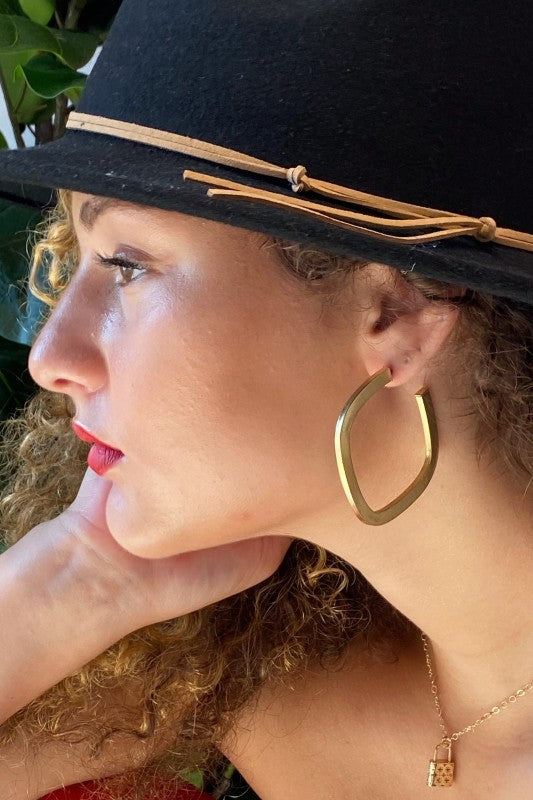 Model wearing Overall Luxe Square Hoop Earrings; lightweight satin gold finish with bold open-square design.