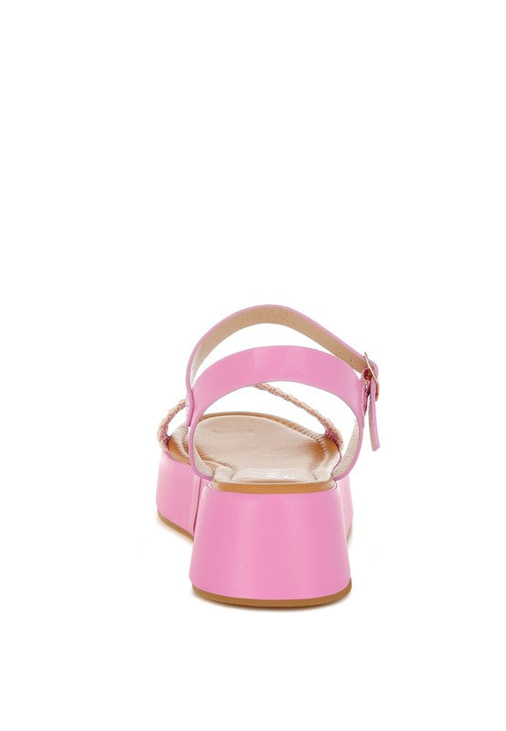 Back view of pink woven raffia flatform sandals with adjustable pin buckle strap and 2-inch platform heel.