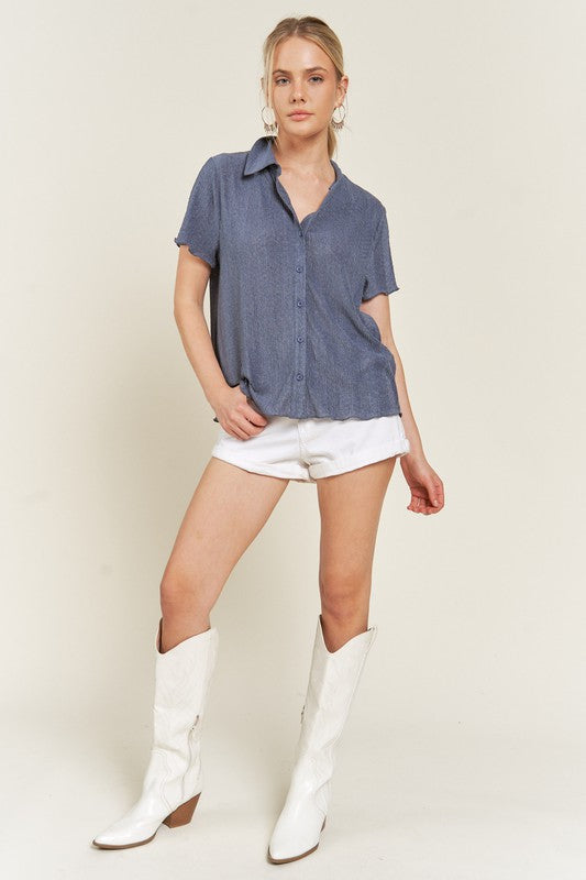 Full body view of short sleeve denim blue textured button down top.