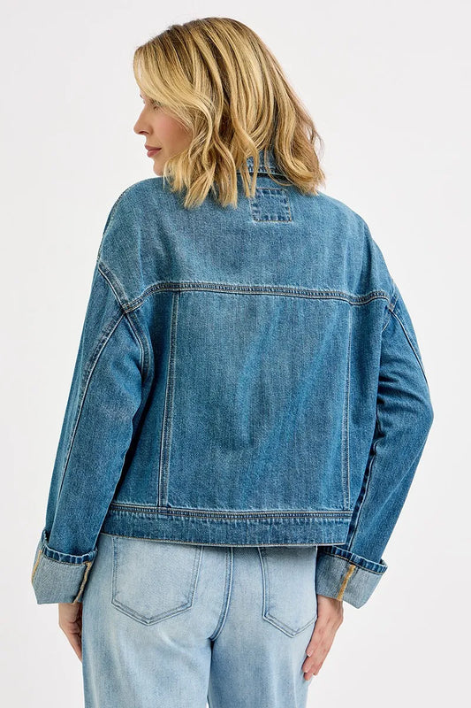 Back view of oversized denim jacket with relaxed fit and structured shoulders.