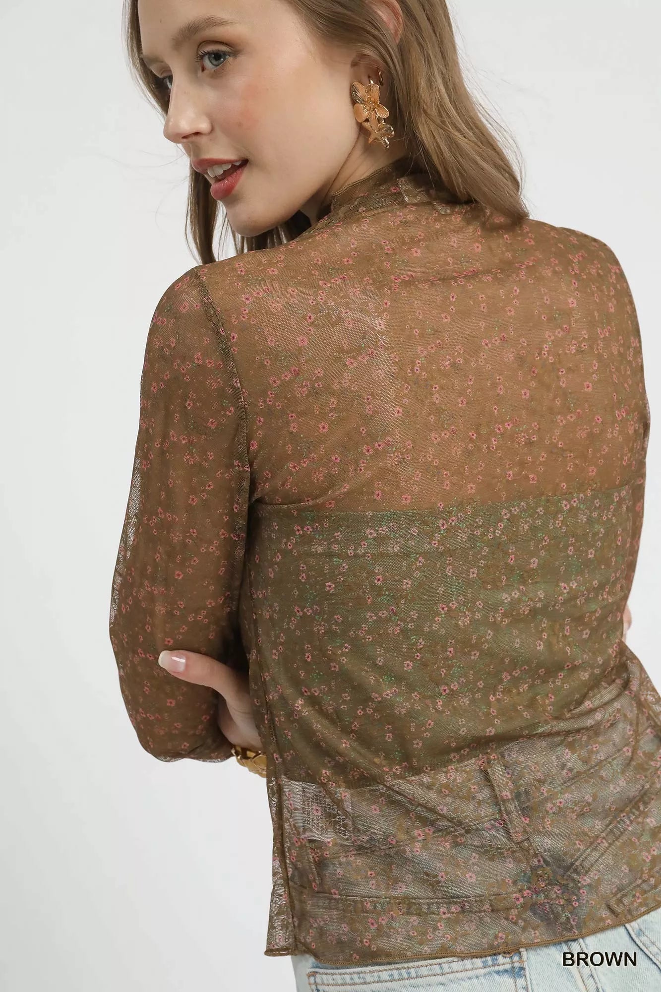 Brown lace mesh top on model, close-up showing sheer floral sleeve detail.
