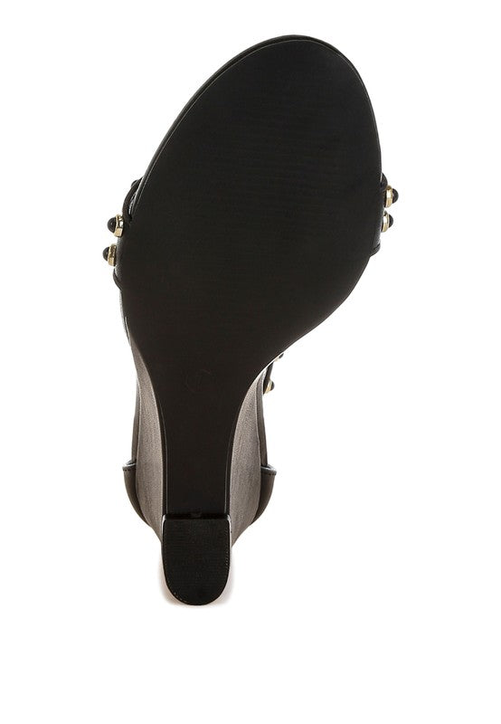 Bottom sole view of black wedge sandals with rubber outsole.