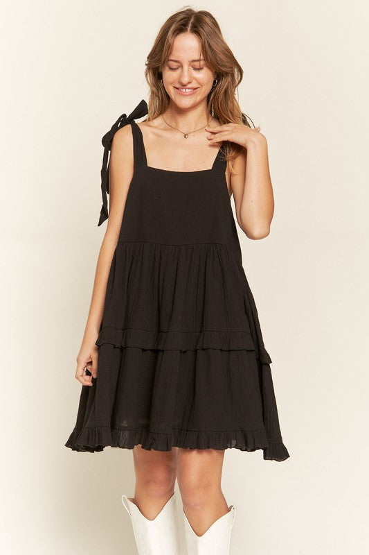 Front view of model wearing Edwina Plus Size Square Neck Ruffle Dress in black, styled for a casual chic look.
