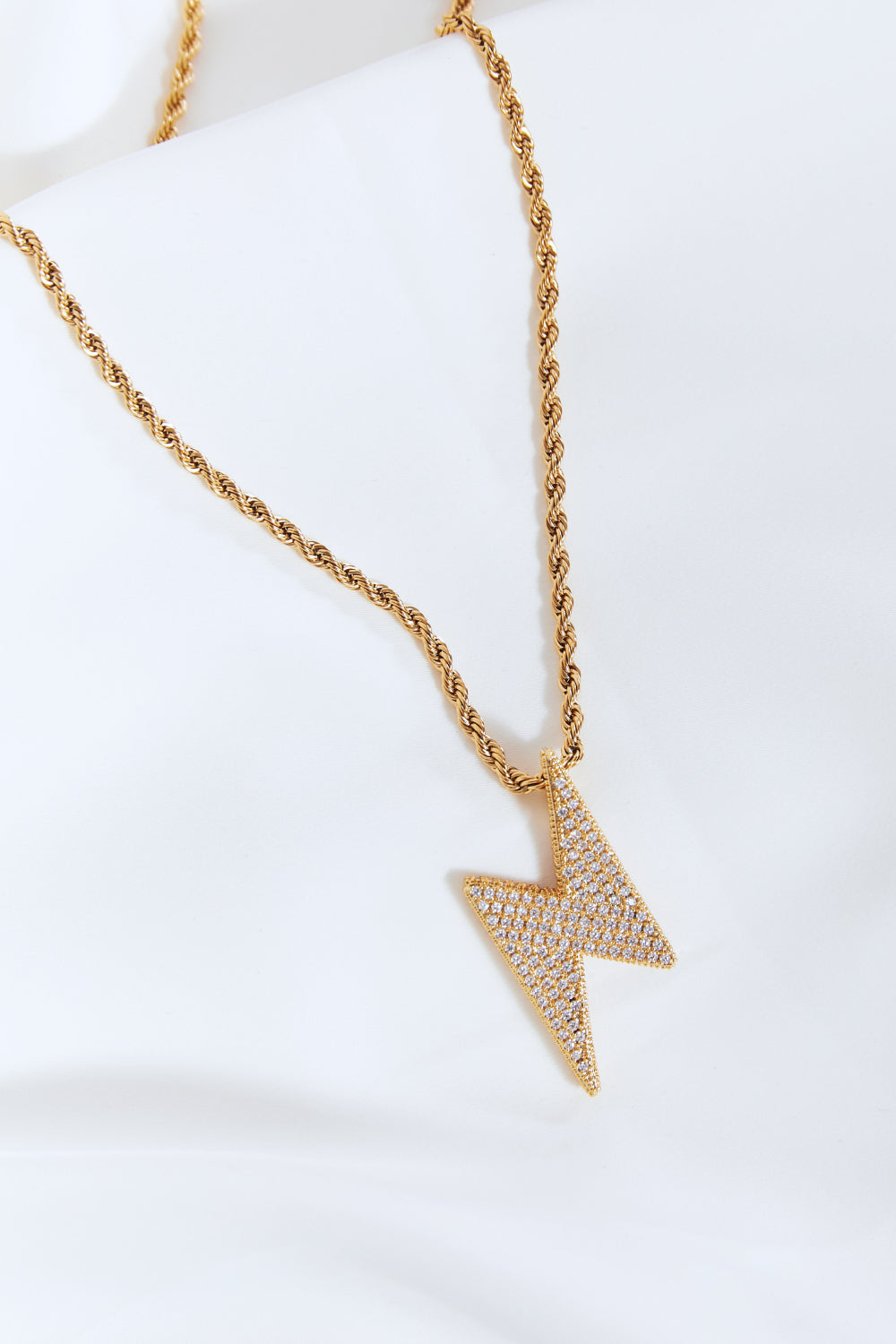 Lightning pendant necklace with a twisted chain, crafted from brass, stainless steel, and cubic zirconia for a sparkling touch.