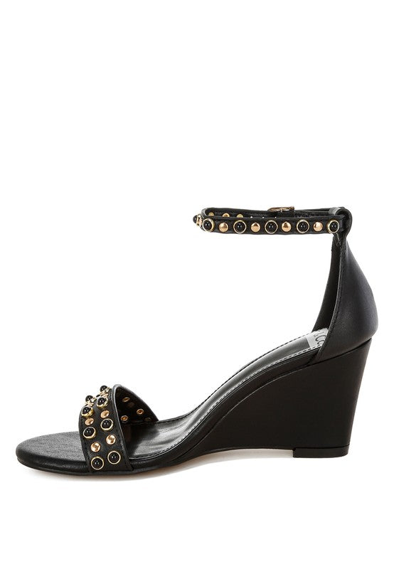 Medial side view black wedge sandals with studded ankle strap.
