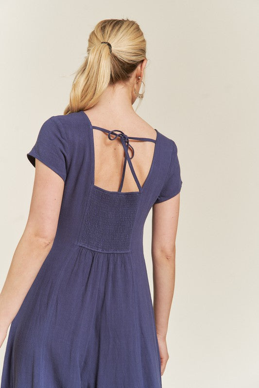 Back view of navy Seona Linen Jumpsuit featuring short sleeves and easygoing wide leg cut.