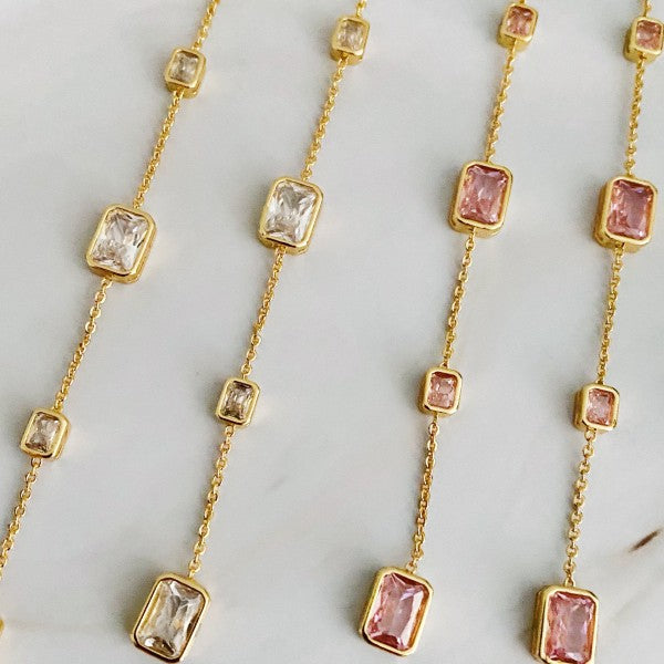 Close-up flat lay of both blush pink and clear Five Stones Dangle Drop Earrings