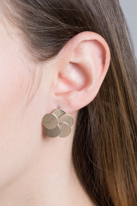 Woman wearing Round and Round Earrings, showing chic gold stud design.