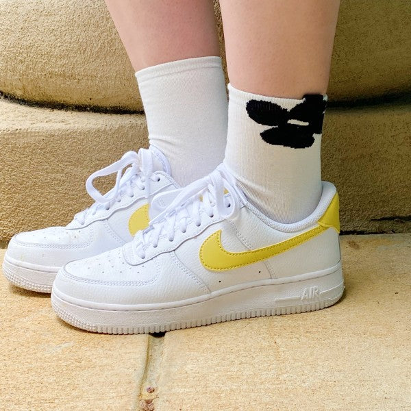 Woman wearing white flower socks from Insiders Only Set styled with sneakers.