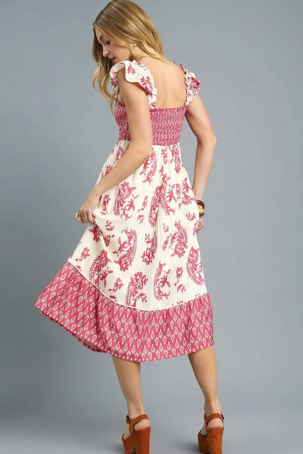 Back view of Isabelle Smocked Floral Midi Dress showing tiered boho skirt and ruffle sleeve accents on a soft cream base.