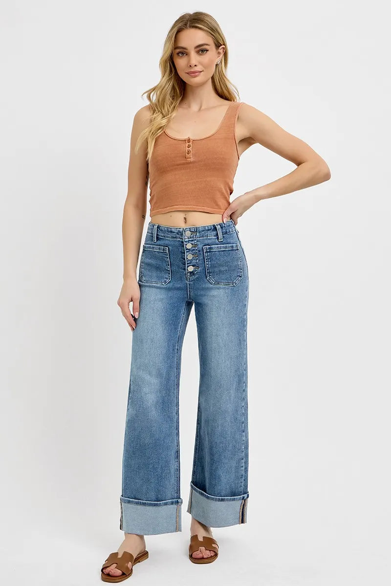 Full body front view of model wearing RISEN Asher high rise wide leg jeans styled with a tank top and sandals – casual, chic look with button fly and cuffed hem