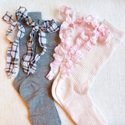 Flat lay of grey and pink Plaid Ruffle Bow Socks showing ruffle bow accents.