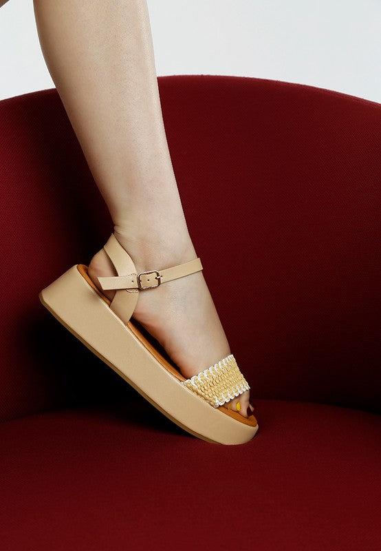 Side view of beige raffia summer sandals with open toe, pin buckle closure, and cushion insole.