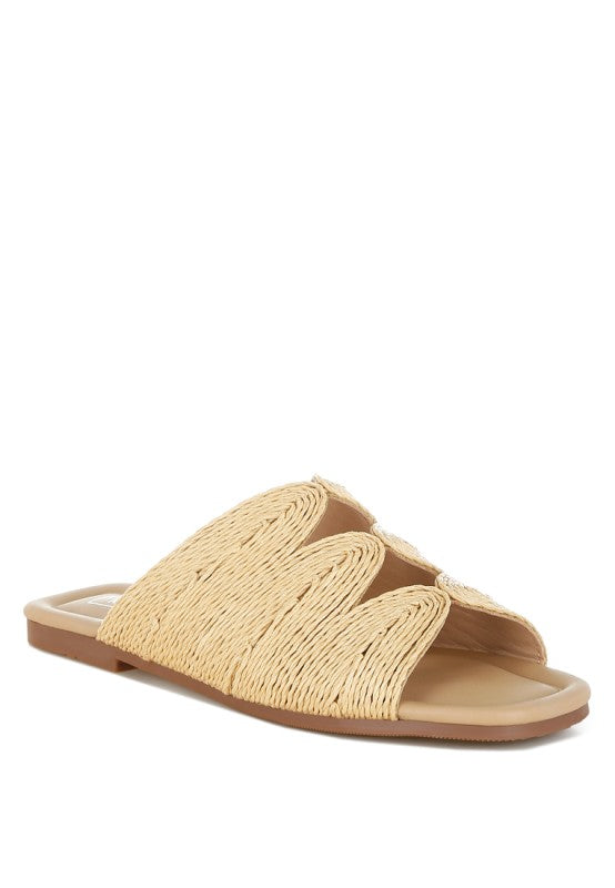 Front angle view of beige Daisy Doe raffia flat featuring an open square toe and cut work detailing.