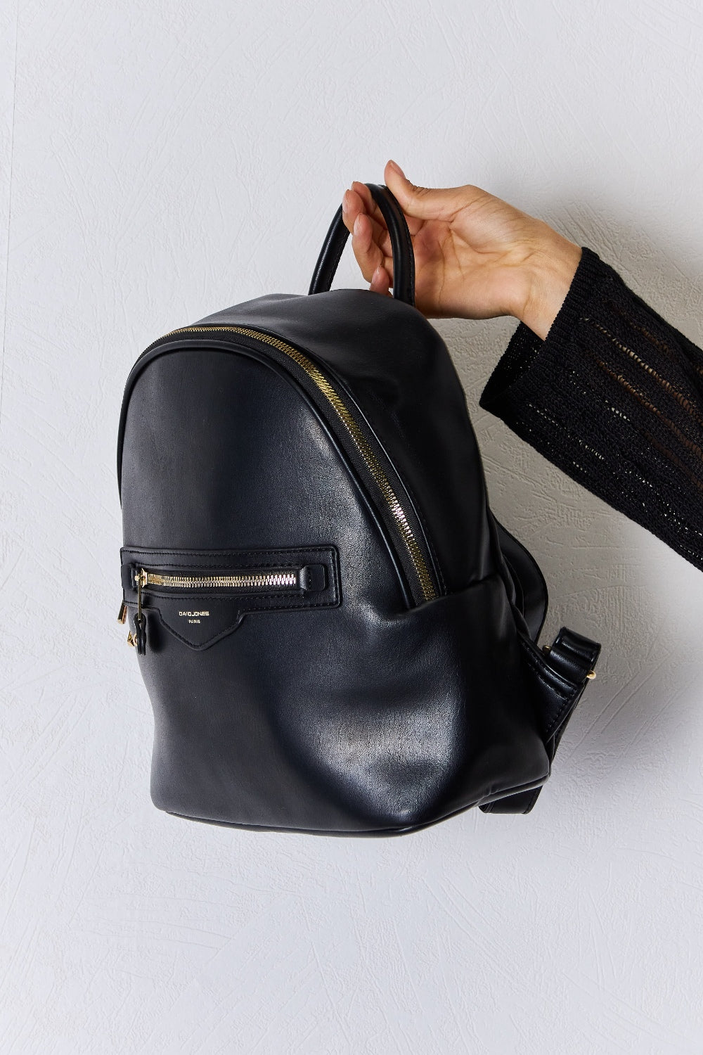 ide view of Garris black vegan leather backpack showing slim medium profile.