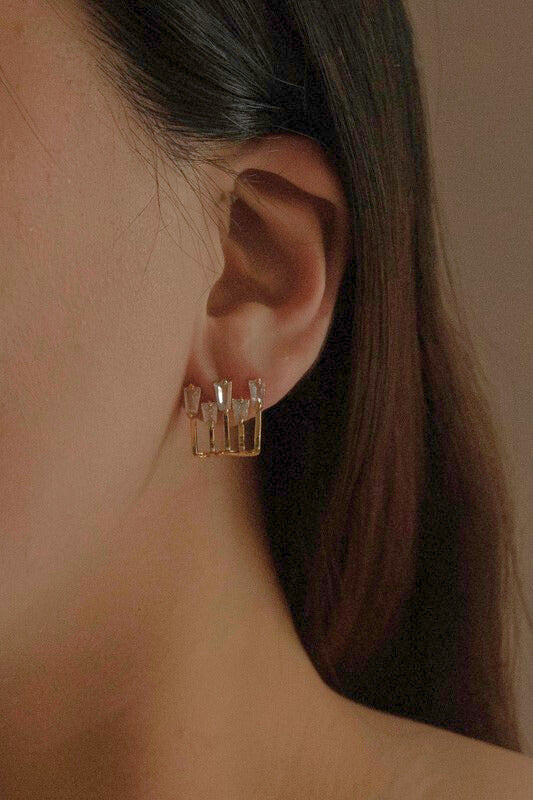 Woman wearing Kalimba Gold Baguette Post Earrings with five baguette stones, adding a touch of gold sparkle.