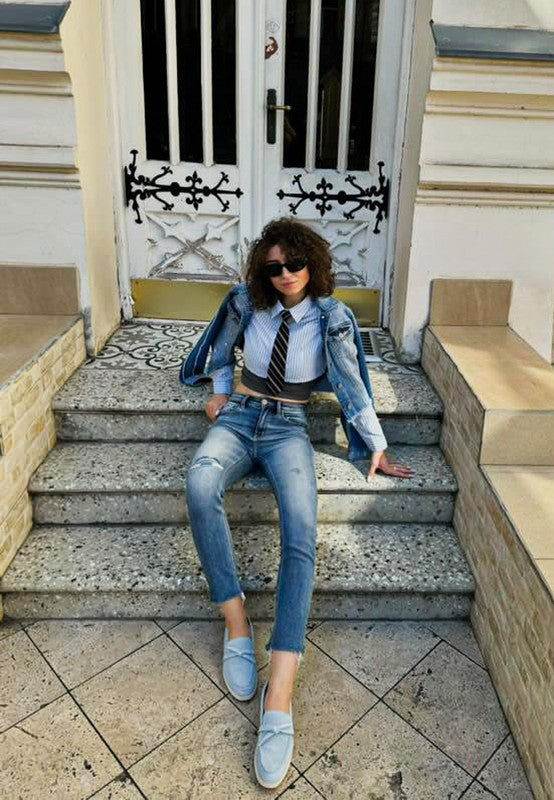 Woman wearing baby blue Nautica suede loafers styled with denim outfit.