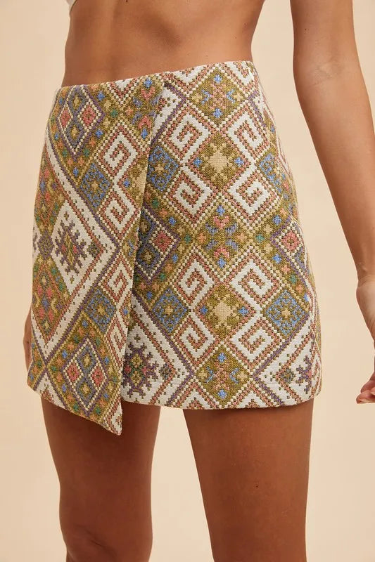 Angle view of Regina Wrap Mini Skirt highlighting textured woven jacquard fabric and bold geometric design.
