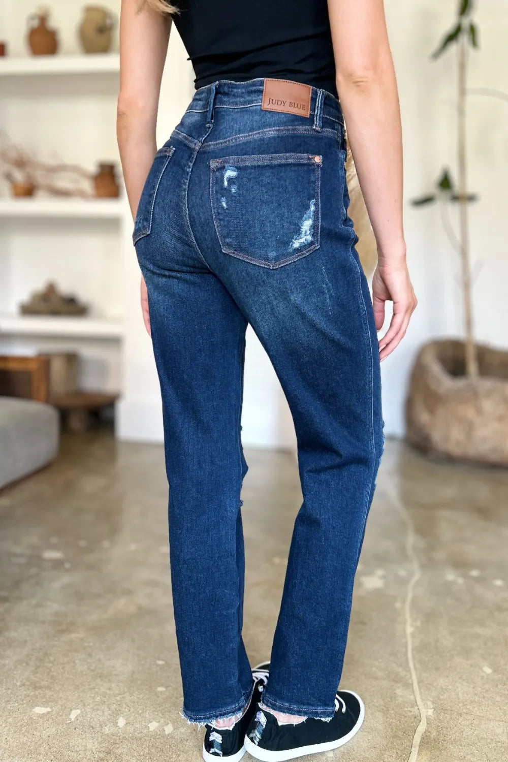 Model in Wynna Jeans back view, showing raw hem and dark wash denim