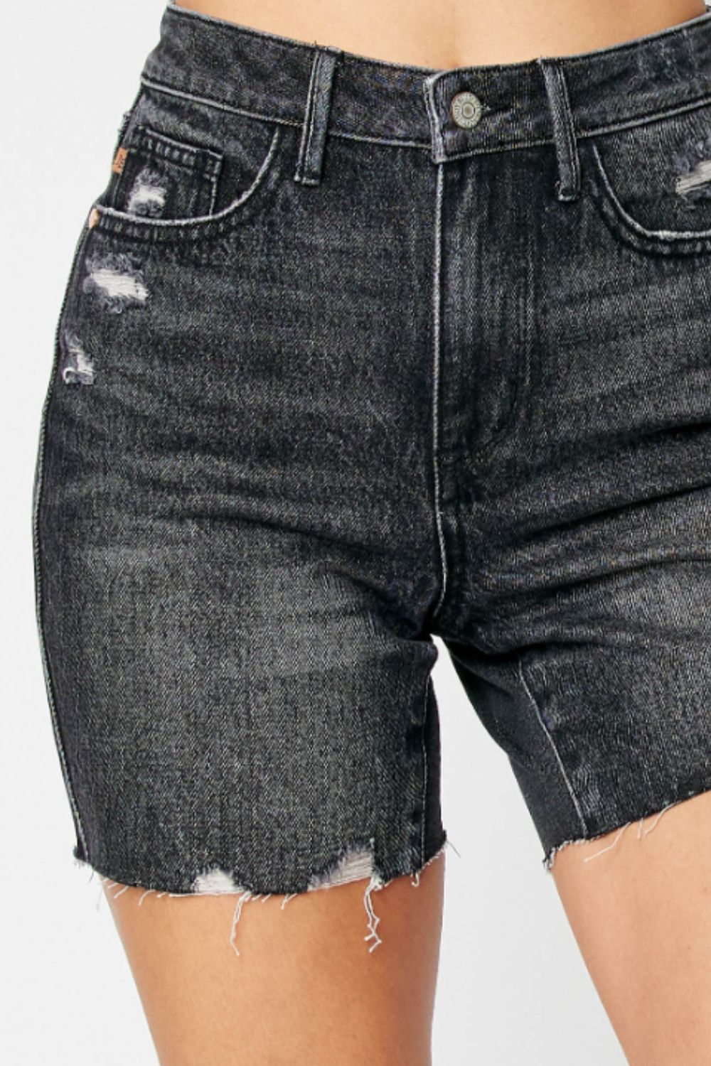Close up of Lucille High Waist Denim Shorts highlighting tummy control waist, raw hem, and black denim fabric.