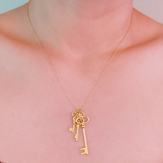Woman wearing Secret Garden Key Necklace with vintage gold key charms hanging elegantly