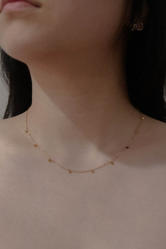 Woman wearing Golden Dot Charm Necklace with minimalist design