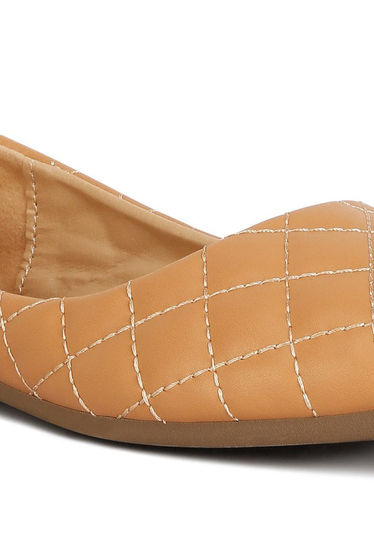 Close-up of beige quilted detail on ballet flats.