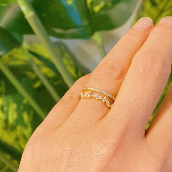 Colette Jeweled Ring worn on woman’s hand, close up showing gold double band and jewels
