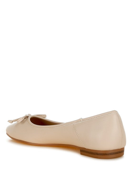 Back angle of beige vegan leather ballerinas with bow detail, cushioned insole, and flat heel for stylish everyday comfort.