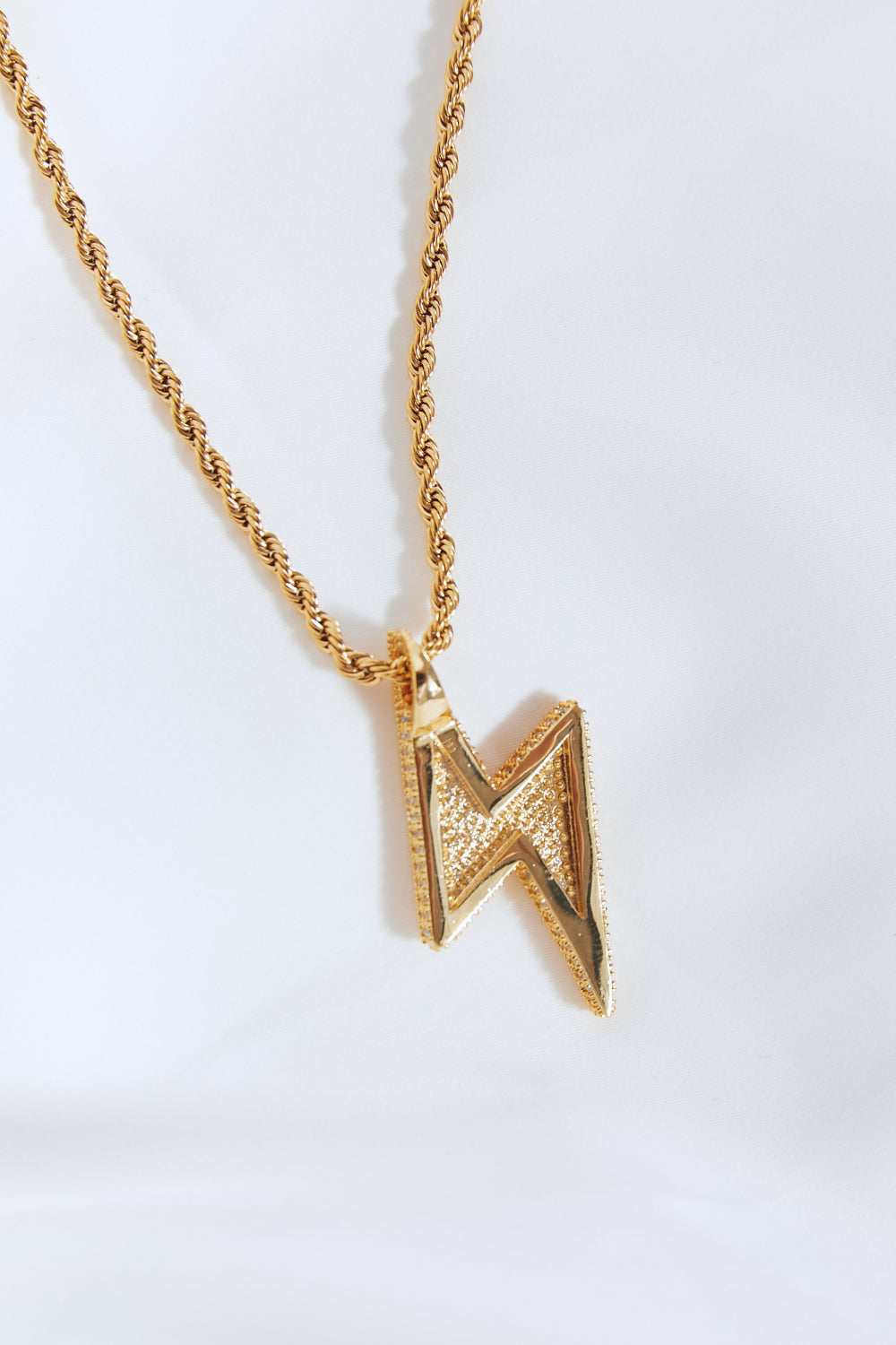 Lightning pendant necklace with a twisted chain, crafted from brass, stainless steel, and cubic zirconia for a sparkling touch.