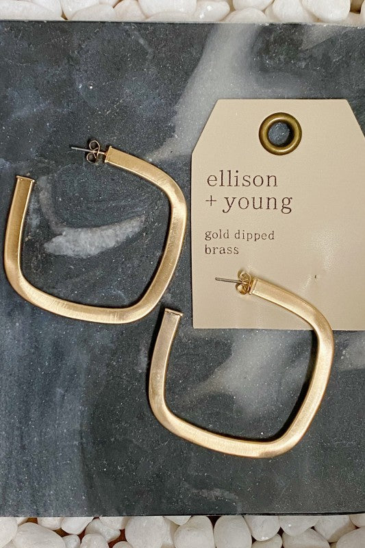 Close-up flat lay of Overall Luxe Square Hoop Earrings on marble, showing satin gold plating and open square shape.