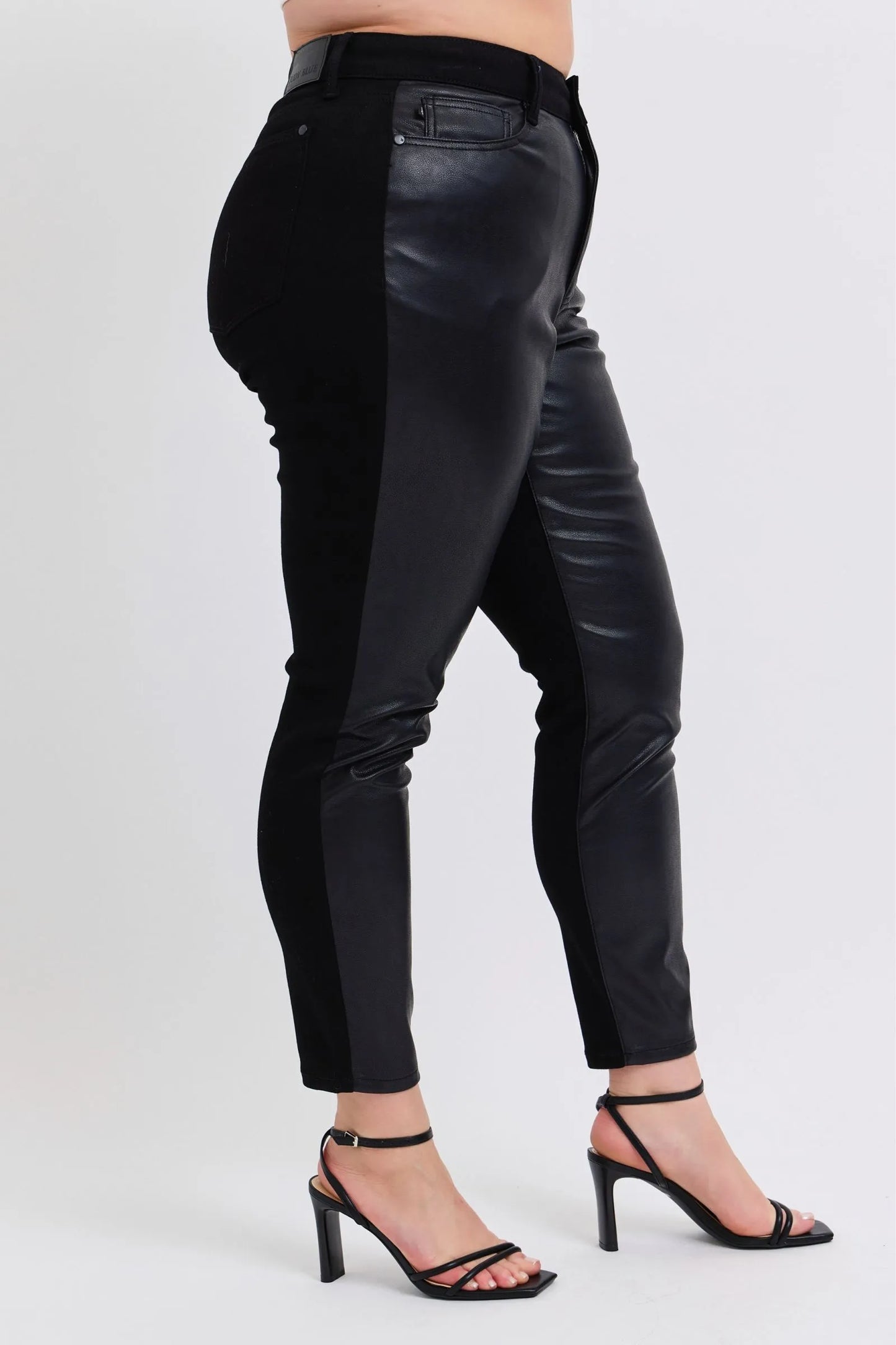 Plus model side view of Kat faux leather pants, high-rise skinny fit with stretch, sleek black finish.