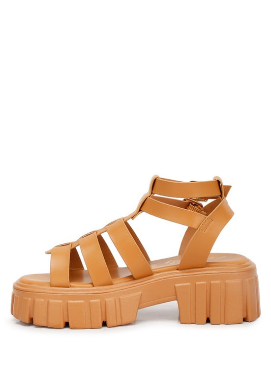 Side angle of tan recycled faux leather gladiators with adjustable buckle straps.