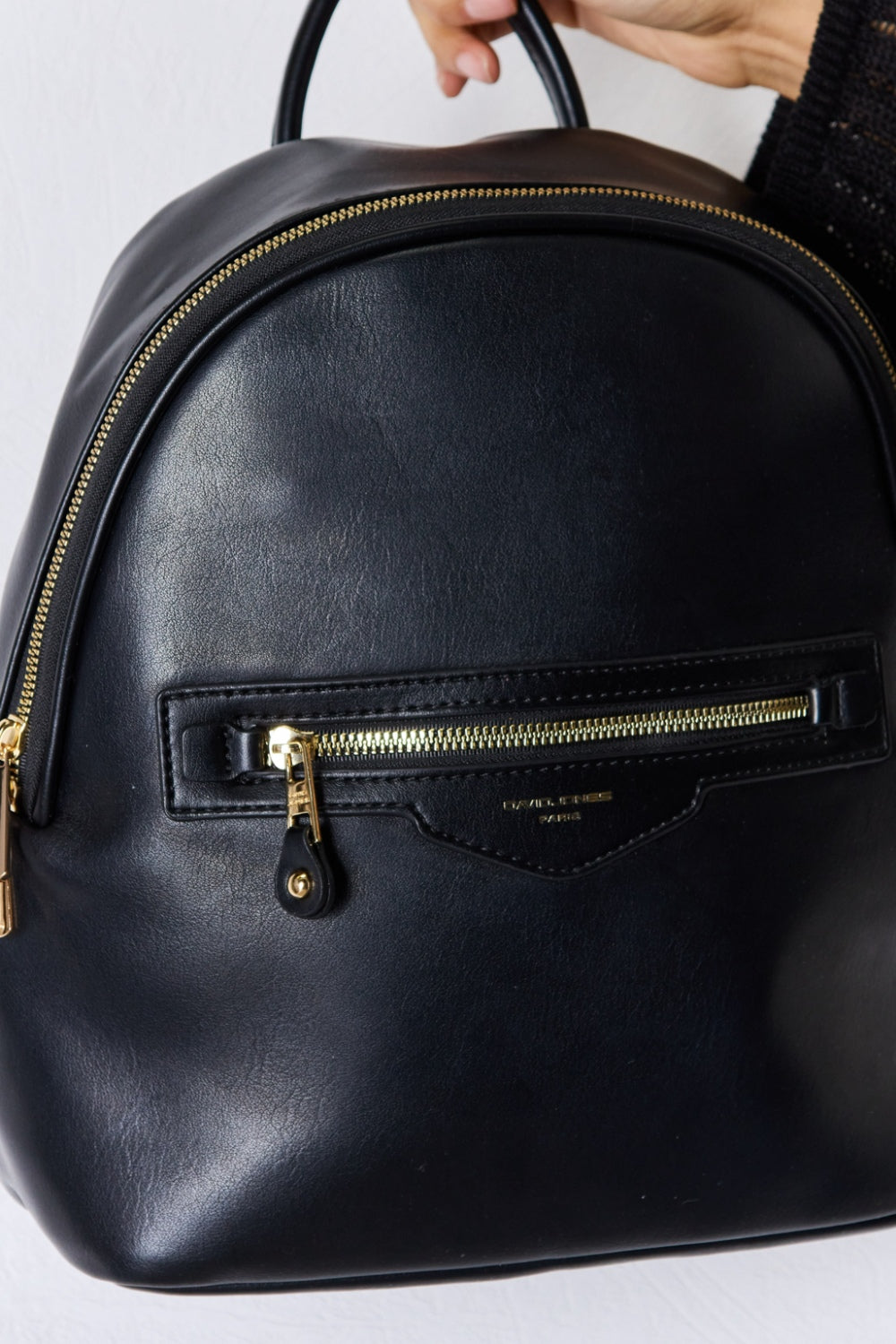 Close-up detail of Garris black vegan leather backpack texture and gold-tone hardware.