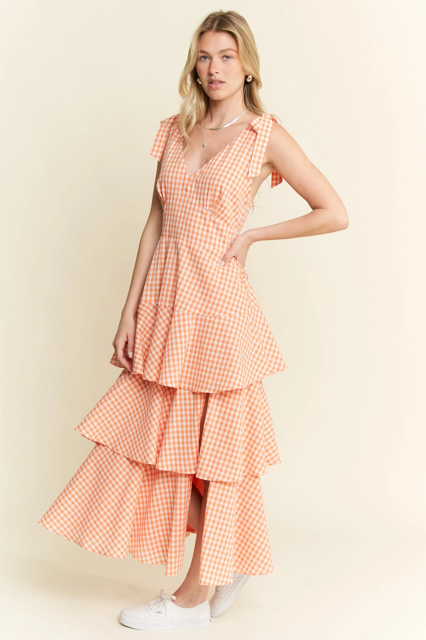 Front angled view of Alice Gingham Tiered Midi Dress by Jade by Jane, highlighting V-neckline, halter tie straps, and tiered orange gingham skirt.