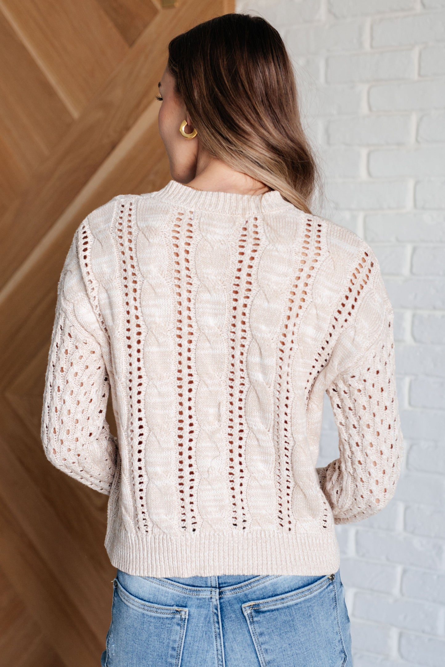 Back view of Natalia Cream Cable Knit Sweater with ribbed hem and relaxed fit, perfect for casual layering.