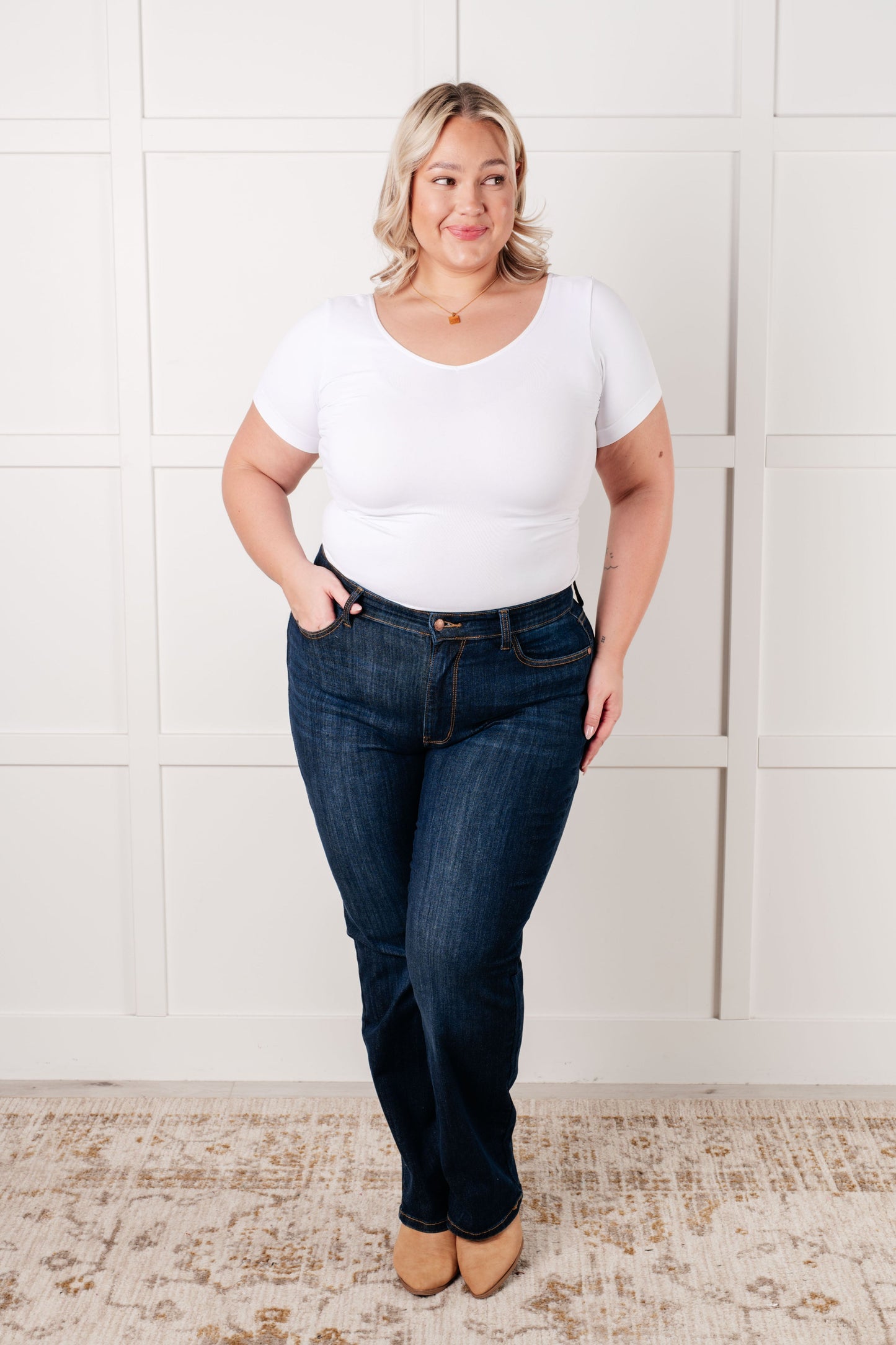 Plus size model wearing the Judy Blue dark wash high-rise straight-leg jeans with a zip fly, 4-way stretch, and a non-distressed design.