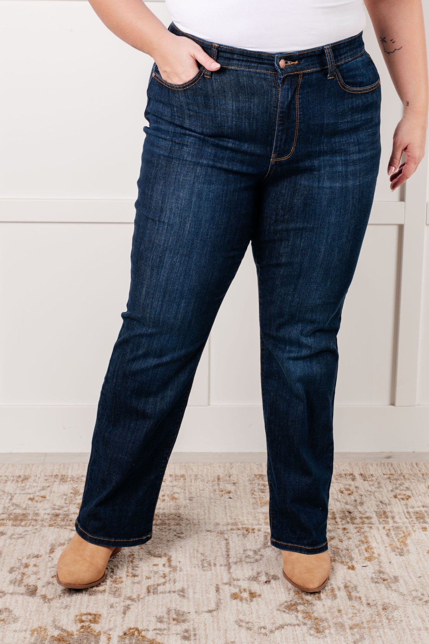 Plus size model wearing the Judy Blue dark wash high-rise straight-leg jeans with a zip fly, 4-way stretch, and a non-distressed design.