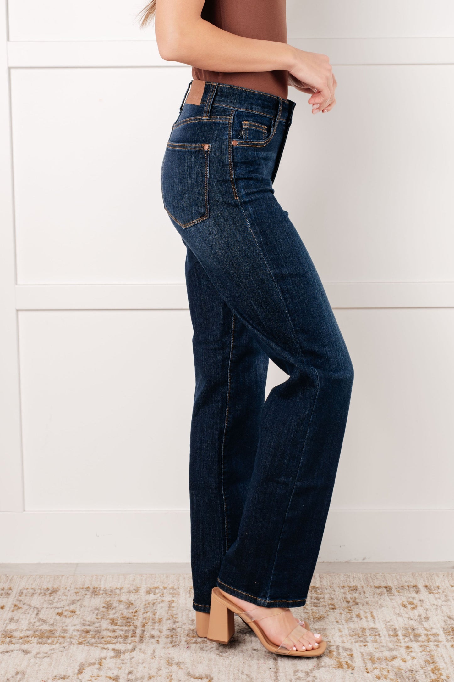Side view of model wearing the Judy Blue dark wash high-rise straight-leg jeans with a zip fly, 4-way stretch, and a non-distressed design.