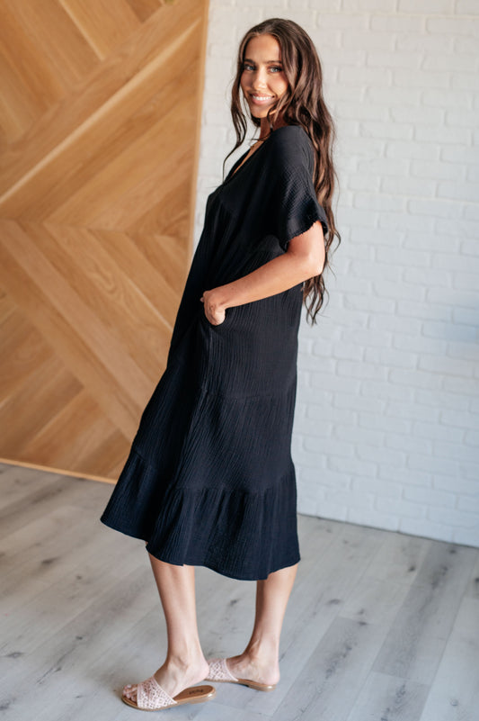 Side view of Dani Dolman Sleeve Dress in black with dolman sleeves, crinkle woven fabric, and flattering flowy silhouette.
