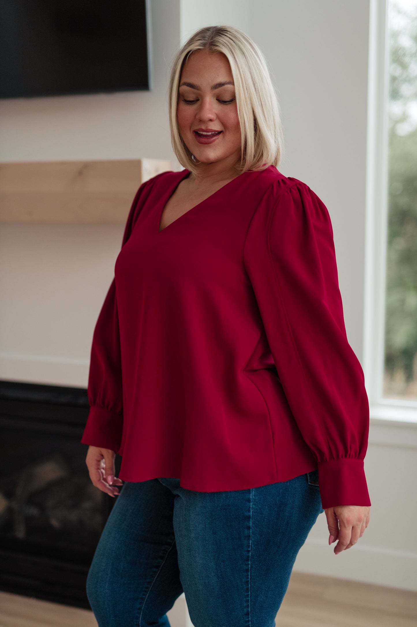 Wine-colored lightweight woven blouse with a V-neckline, long puff sleeves, and buttoned sleeve cuffs.