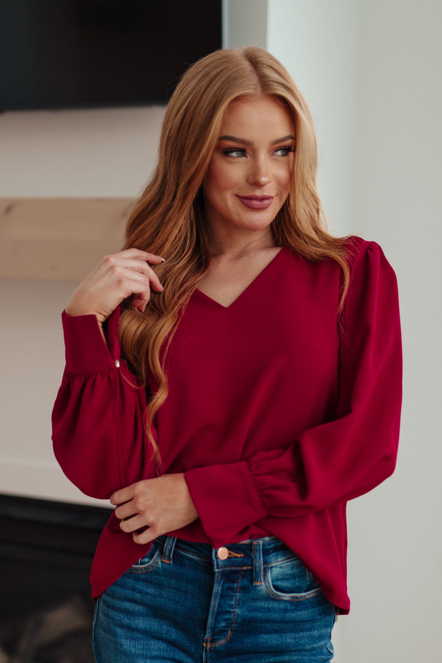 Woman in deep wine Birdie V-Neck Blouse with puff sleeves, front view.