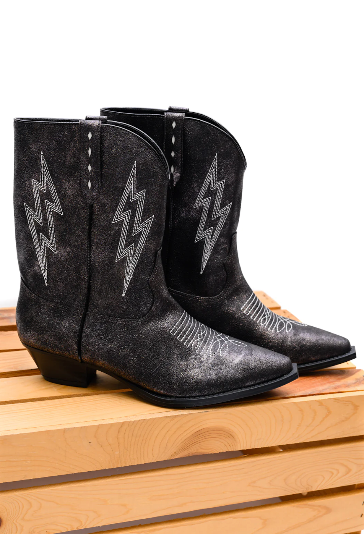 Black metallic Bowie boots with lightning bolt embroidery, front view.