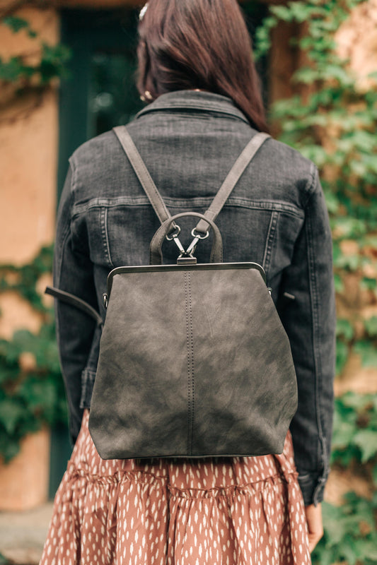 Woman wearing the Bridget Mini Charcoal Backpack over a jean jacket, styled as a backpack for a casual hands-free look.