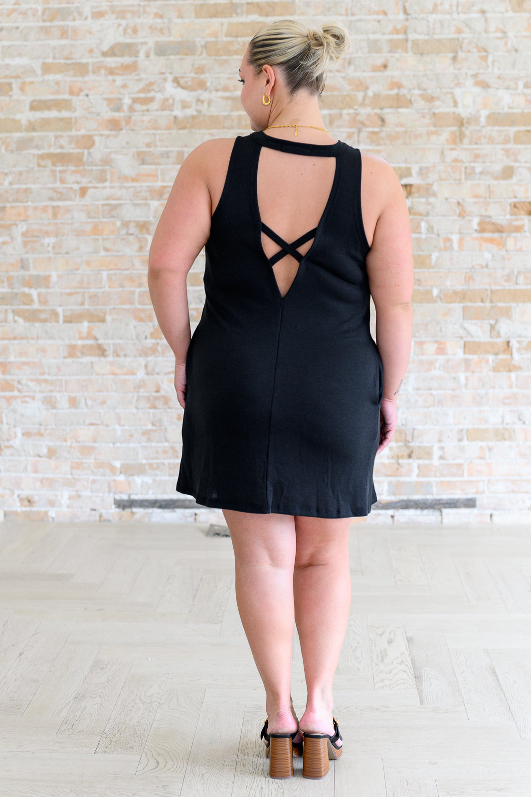 Back view plus size Brynlee black dress, sleeveless with crisscross cut-out detail.