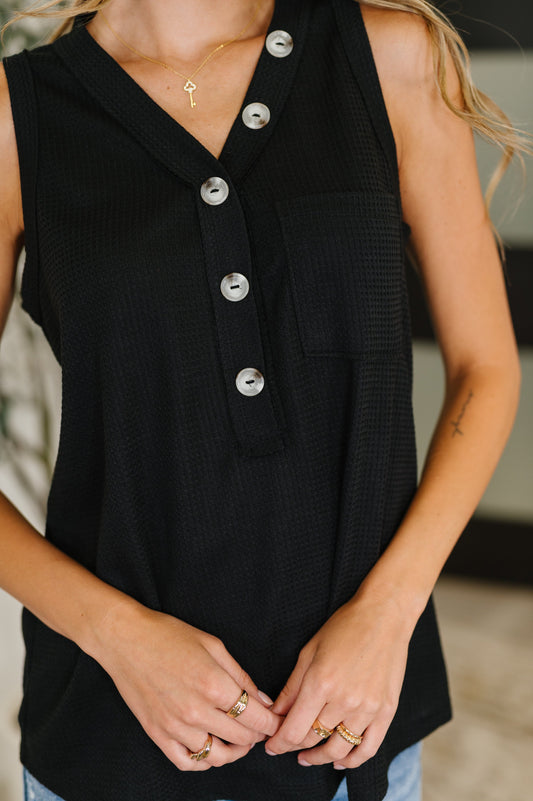 Close-up of Alani Black Sleeveless Top’s faux buttons and functional patch pocket.