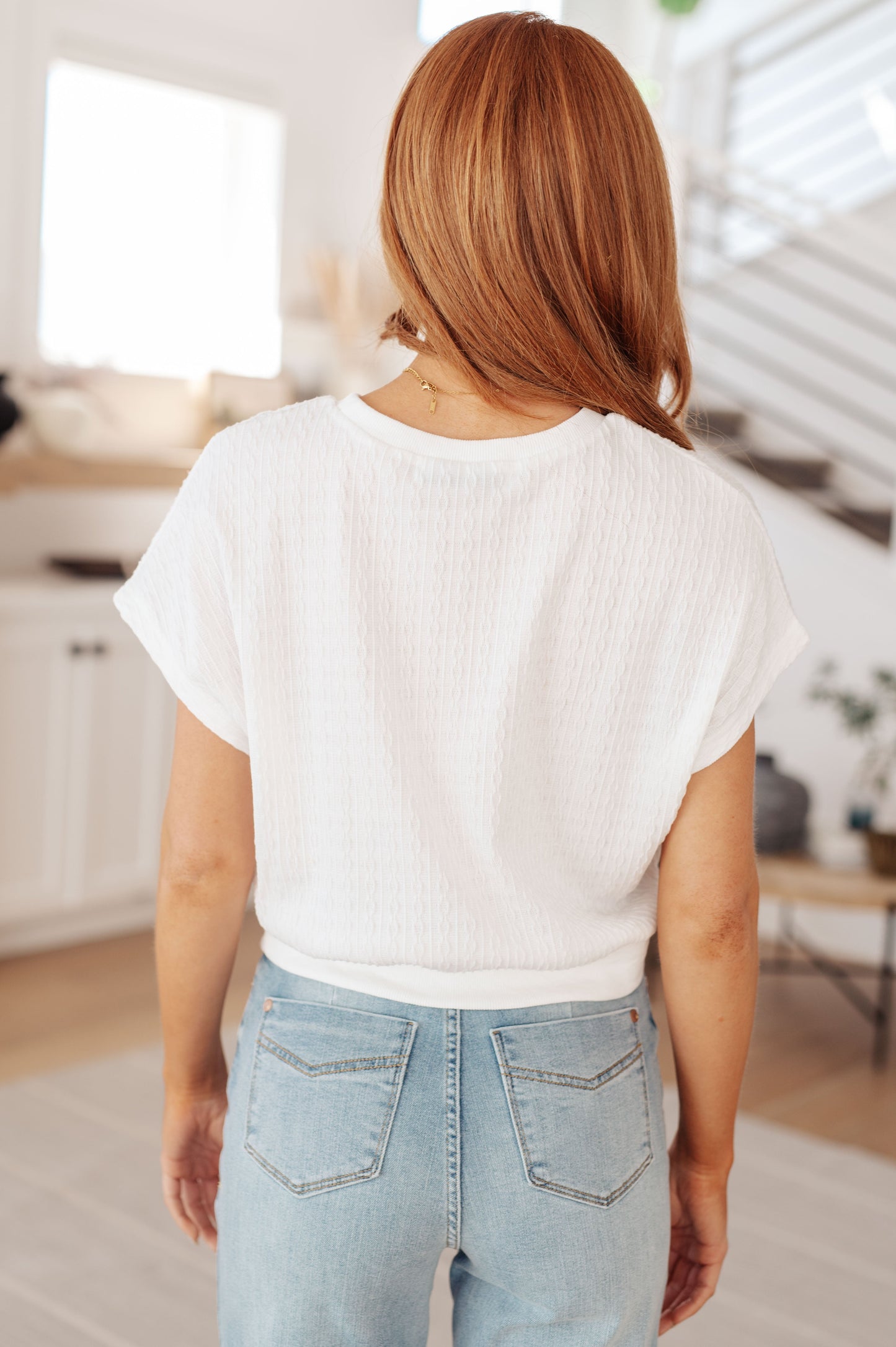 Back view of Claudine white cable knit short sleeve top with batwing sleeves and snug ribbed hem.